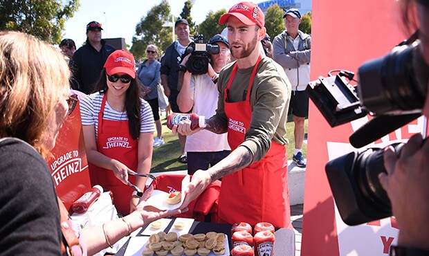 Jeremy Howe handing out pies with Heinz sauce at Friday's practice match - Collingwood Magpies